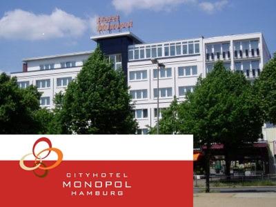 ein großes weißes Gebäude mit den olympischen Ringen oben in der Unterkunft Cityhotel Monopol in Hamburg
