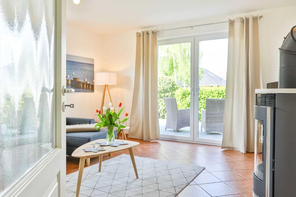 een woonkamer met een vaas met bloemen op een tafel bij Ferienwohnung Möwe in Lanken