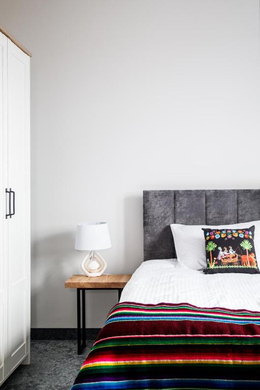 a bedroom with a bed and a table with a lamp at Stara Kuźnia in Łuków