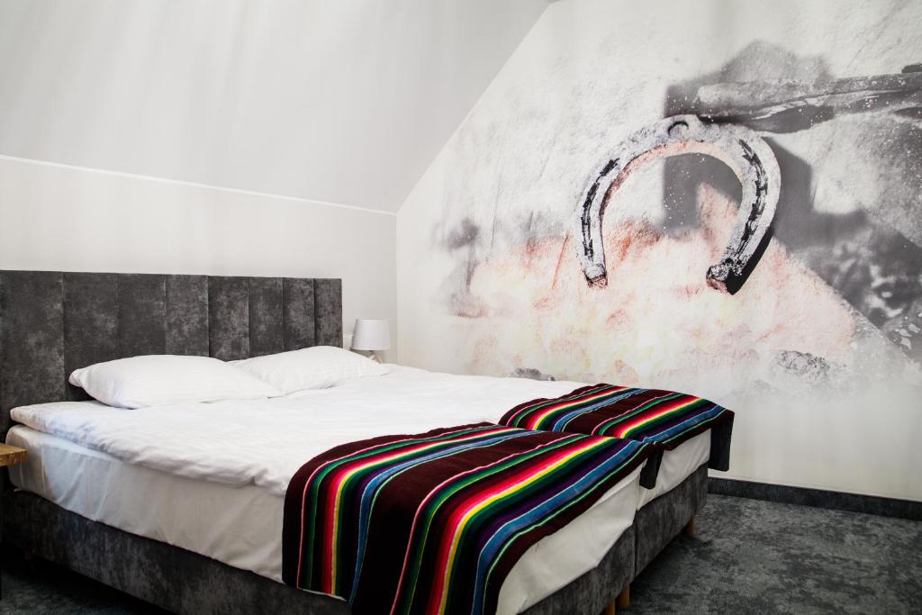 a bedroom with a bed with a painting on the wall at Stara Kuźnia in Łuków