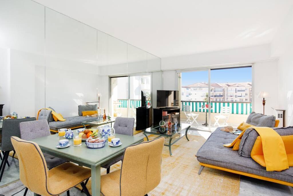 un salon avec une table et des chaises dans l'établissement ELEGANCE YourHostHelper, au Cannet