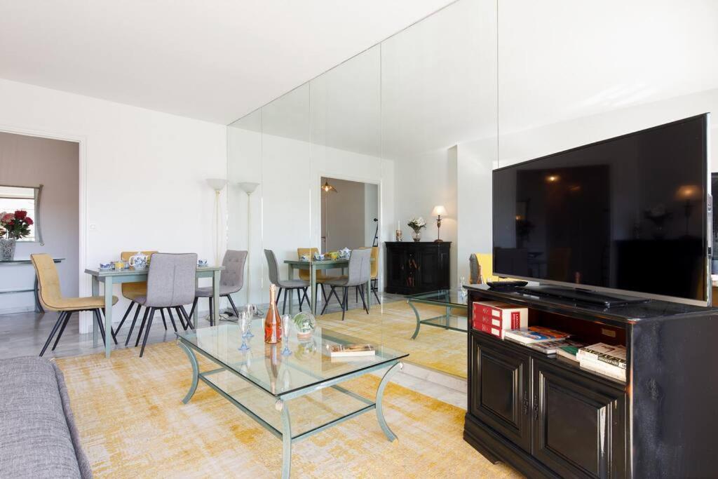 a living room with a large television and a table at ELEGANCE YourHostHelper in Le Cannet