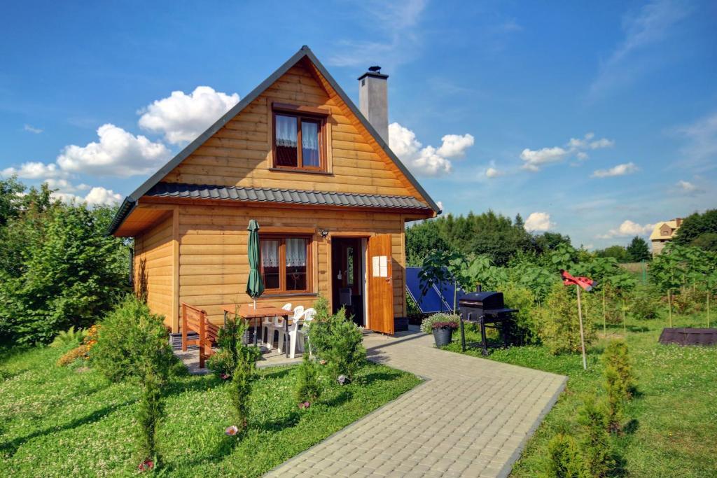 una pequeña casa de madera con un camino delante de ella en Domek Twórczy Kąt, en Święta Katarzyna
