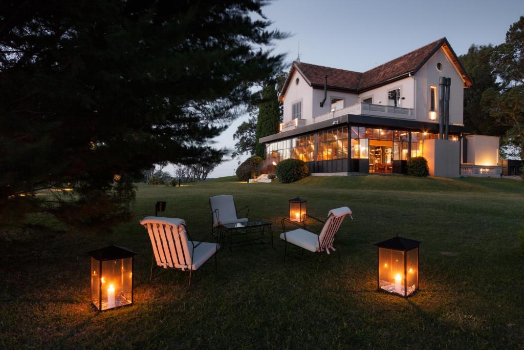 a house with chairs and lights in the yard at LAS LIEBRES RESTAURANT & HOTEL in Colonia del Sacramento