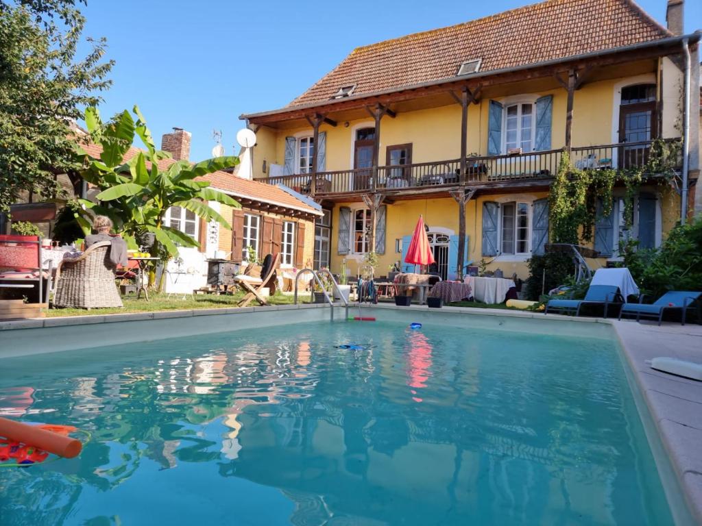 a swimming pool in front of a house at Villa Imaginaire in Maubourguet