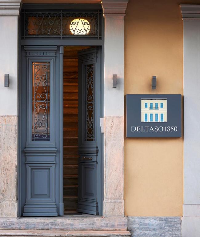 a door to a building with a sign on it at Del Taso 1850 in Athens