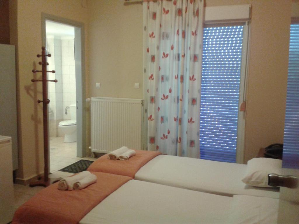 a bedroom with a large bed and a bathroom at Hotel Isidora in Loutrós