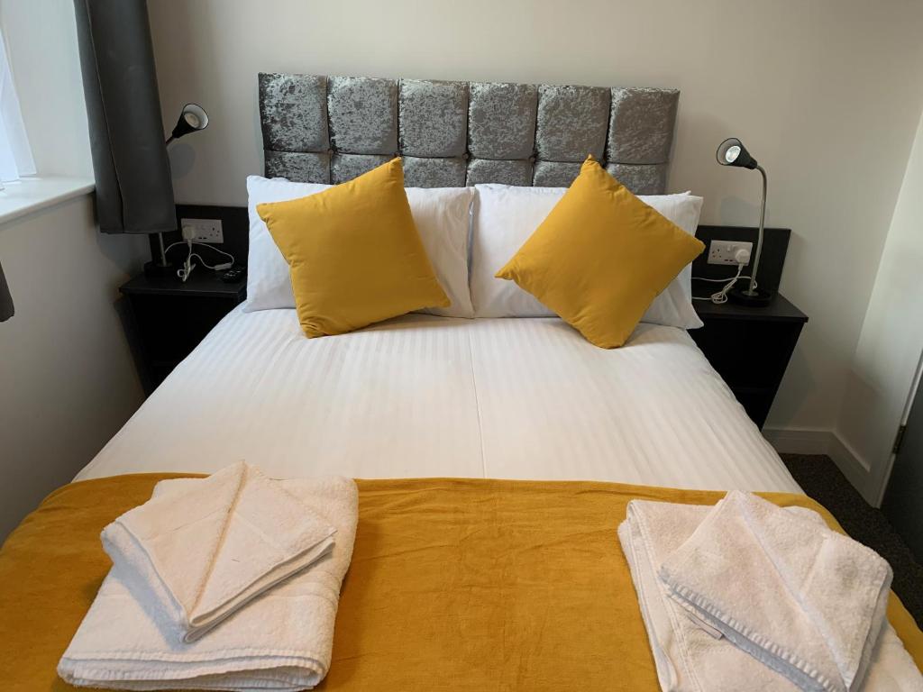 a bedroom with a large bed with two towels on it at Kings Cross by Pureserviced in Plymouth