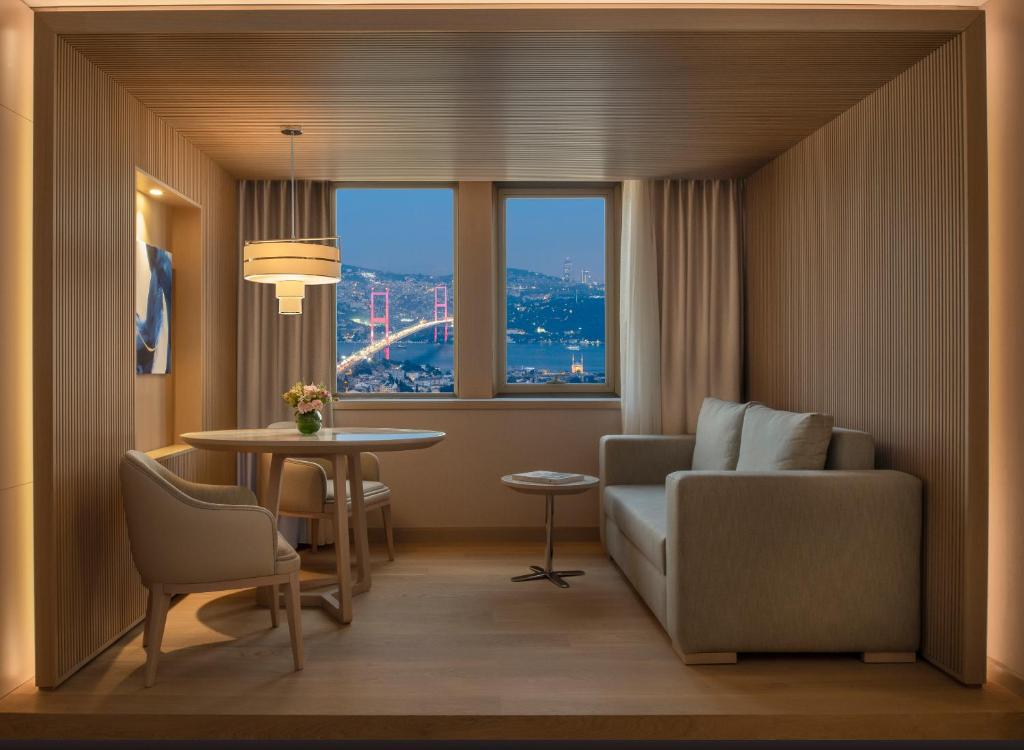 a living room filled with furniture and a window at Mövenpick Hotel Istanbul Bosphorus in Istanbul