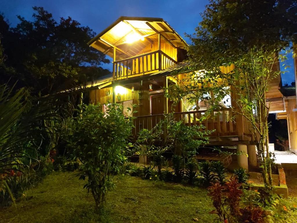 a house with a lit up porch at night at Colinas de Mindo in Mindo