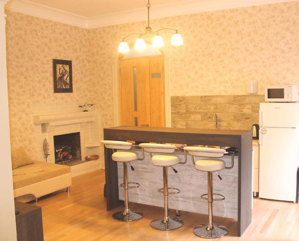 a kitchen with a bar with stools in a living room at Vachnadze Apartment in Tbilisi City