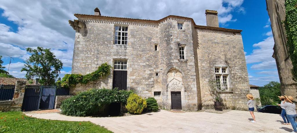 deux femmes debout devant un vieux bâtiment en pierre dans l'établissement Château de Bouniagues, à Bouniagues