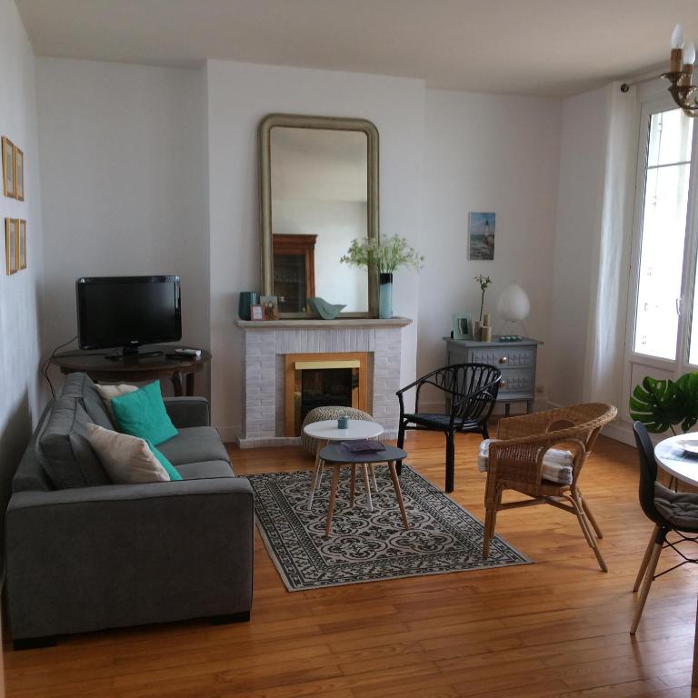 un salon avec un canapé et un miroir dans l'établissement LES FLOTS, à Saint-Valery-en-Caux