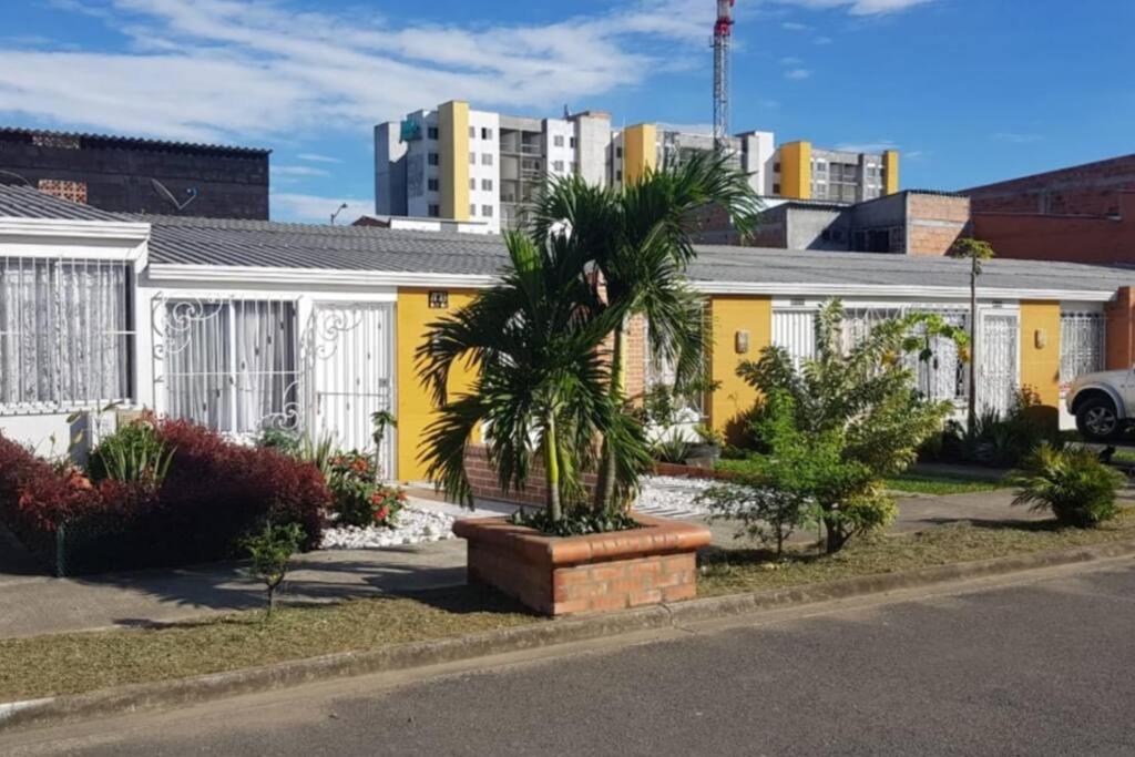 a yellow building with a palm tree in front of it at ALOJAMIENO CERCA A UKUMARI, CONSOTA, EXPOFUTURO in Pereira