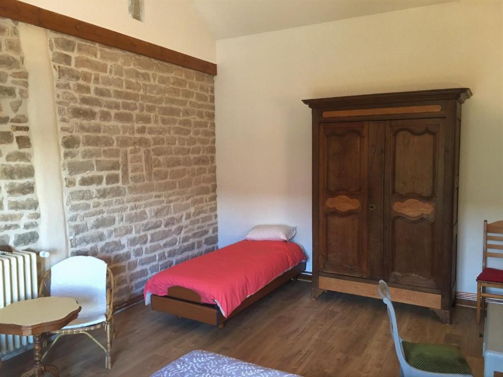 a room with a bed and a brick wall at 2 chambres privées au calme à la Maison des Bambous in Dijon