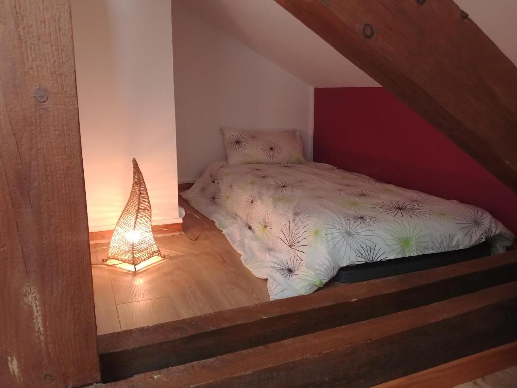 a small bedroom with a bed and a lamp at 2 chambres privées au calme à la Maison des Bambous in Dijon