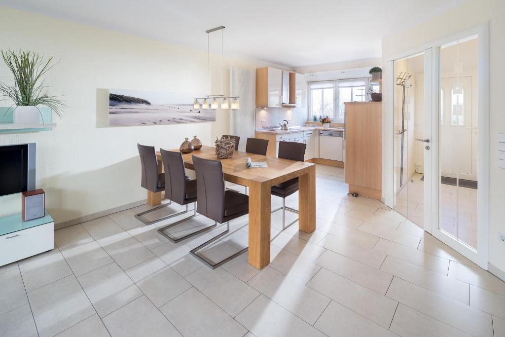 a kitchen and dining room with a table and chairs at Kapitänshaus Roseney in Norderney
