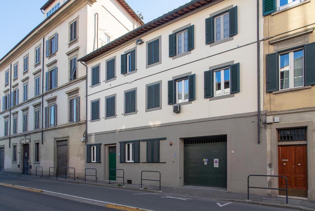 a large white building with green doors and windows at Coco Places Apartments Santa Maria Novella, Centro Storico in Florence