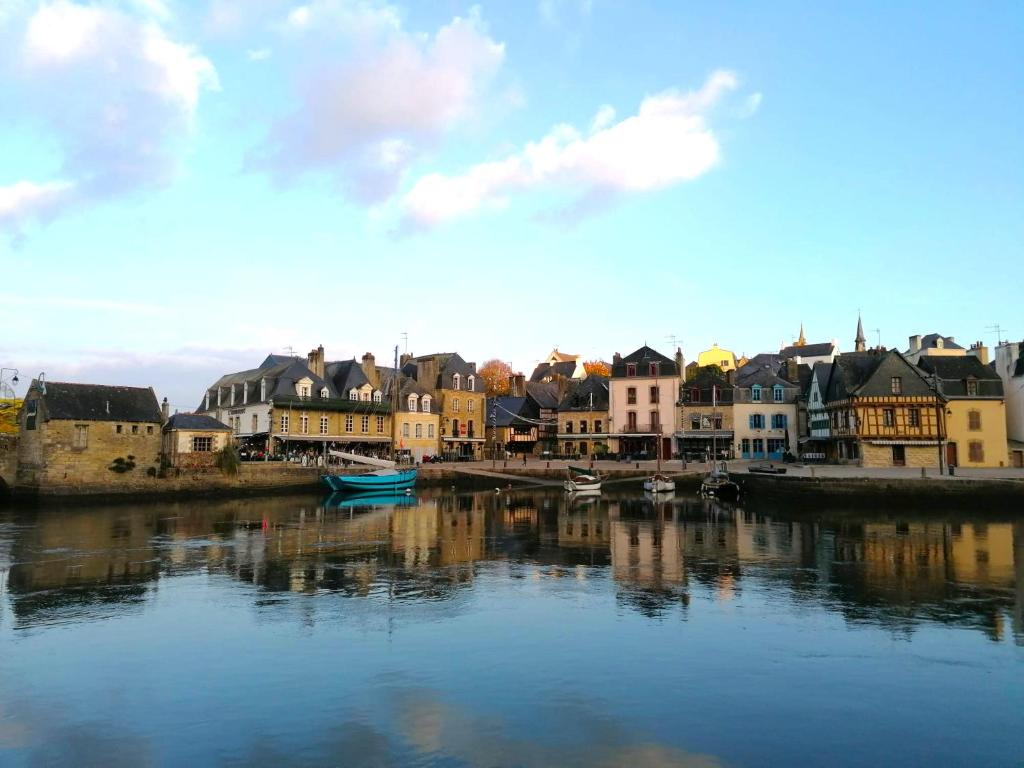 a river with houses and boats in a city at Gîte de l&#39;Hirondelle bleue in Brech