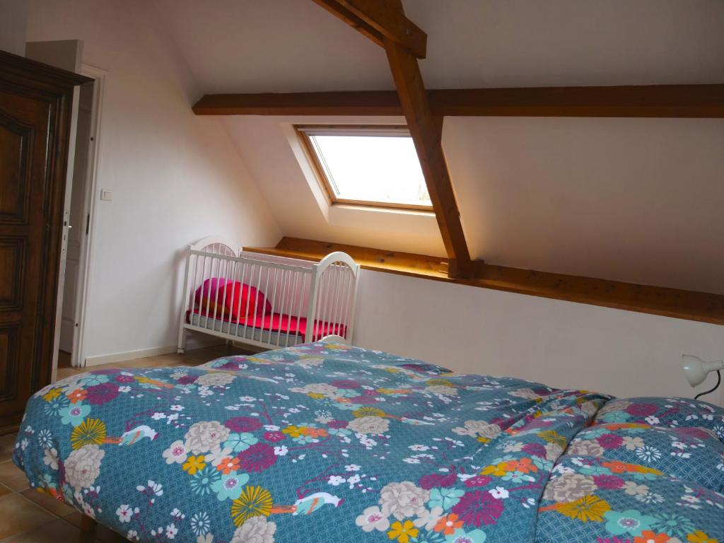 a bedroom with a bed and a window and a crib at Gîte de l&#39;Hirondelle bleue in Brech