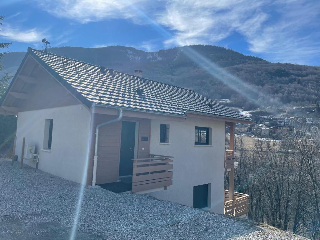 ein kleines weißes Haus mit einem Berg im Hintergrund in der Unterkunft Clos du chapitre T2 - 2pers in Brides-les-Bains