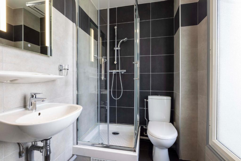 a bathroom with a toilet and a sink and a shower at Bijou Hôtel Paris Boulogne in Boulogne-Billancourt