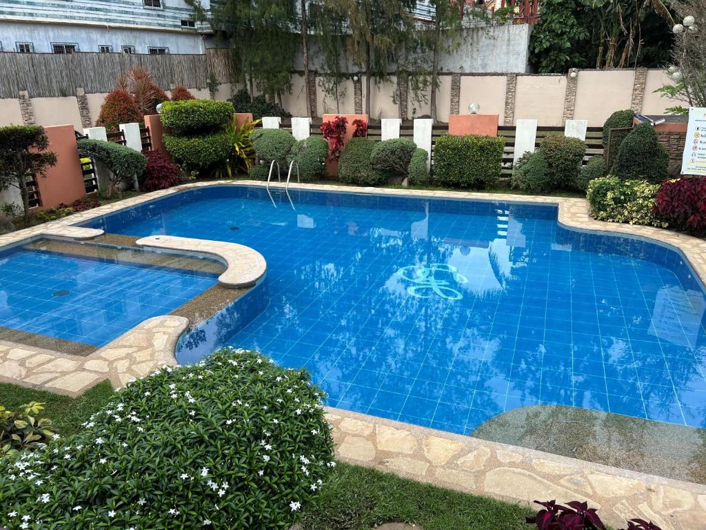 a large blue swimming pool with chairs around it at Tagaytay Hampton Villa in Tagaytay