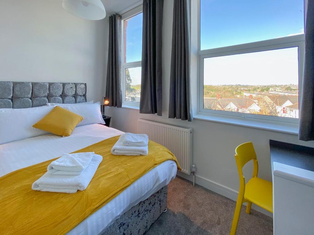 ein Schlafzimmer mit einem Bett mit Handtüchern darauf in der Unterkunft Victoria by Pureserviced in Plymouth