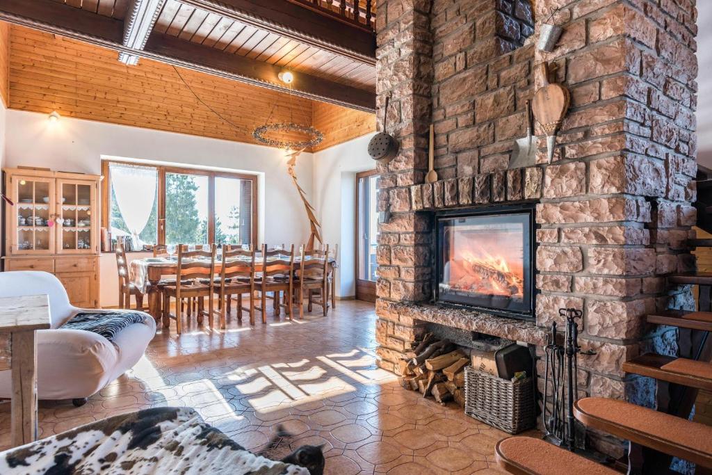 a living room with a stone fireplace and a table at The Lodge Monte Bondone in Vason