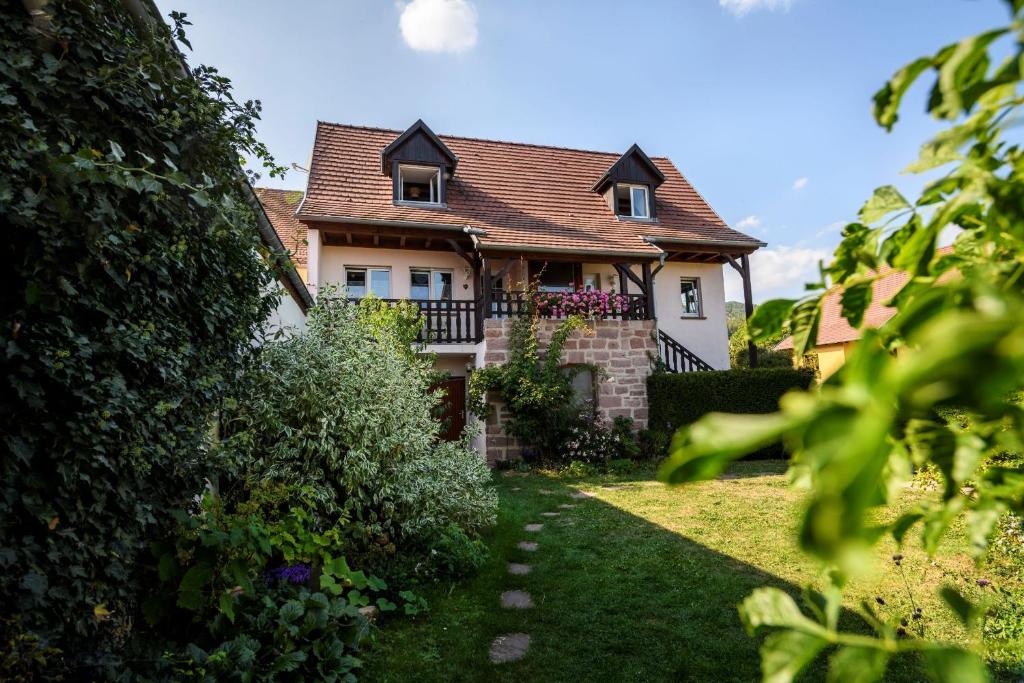 a house with a balcony and a yard at Gîte l'Agapé in Riquewihr