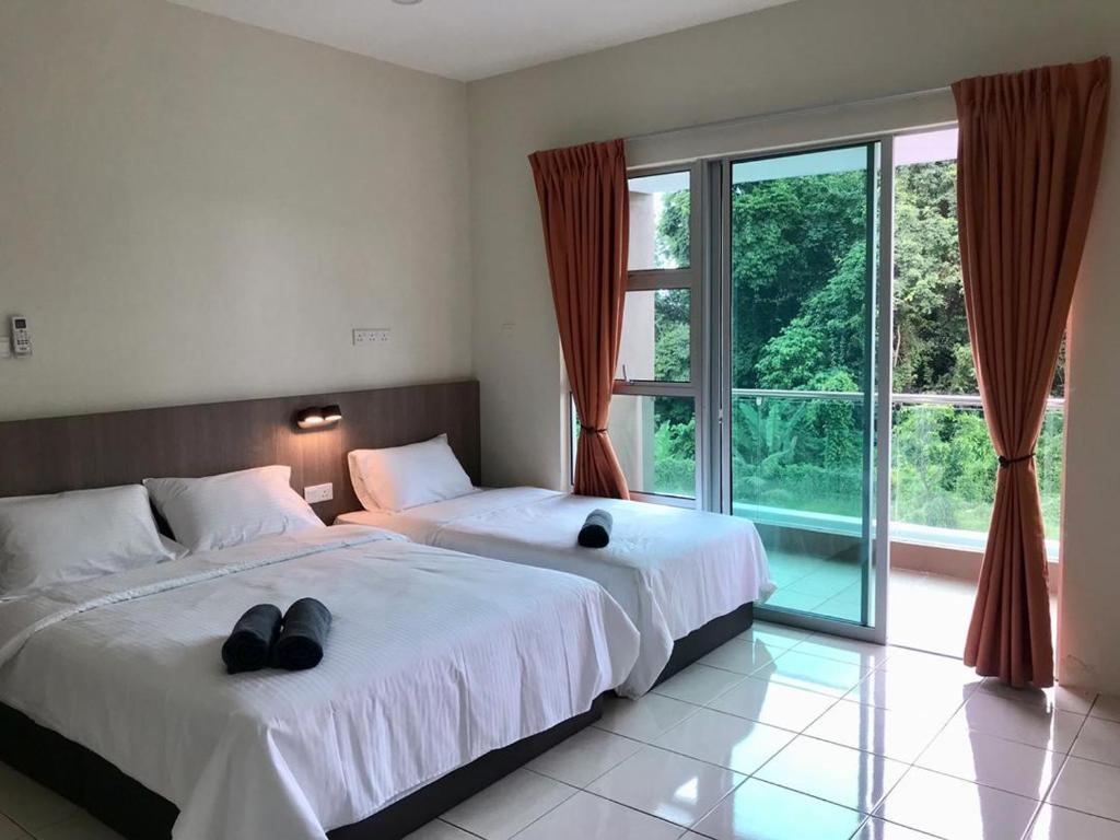 a bedroom with two beds and a large window at IMPIAN STAY #1 #15pax Semi Bungalow House半独立別墅 in Kuah