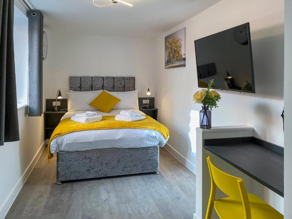 - une chambre avec un lit et une couverture jaune dans l'établissement Euston by Pureserviced, à Plymouth