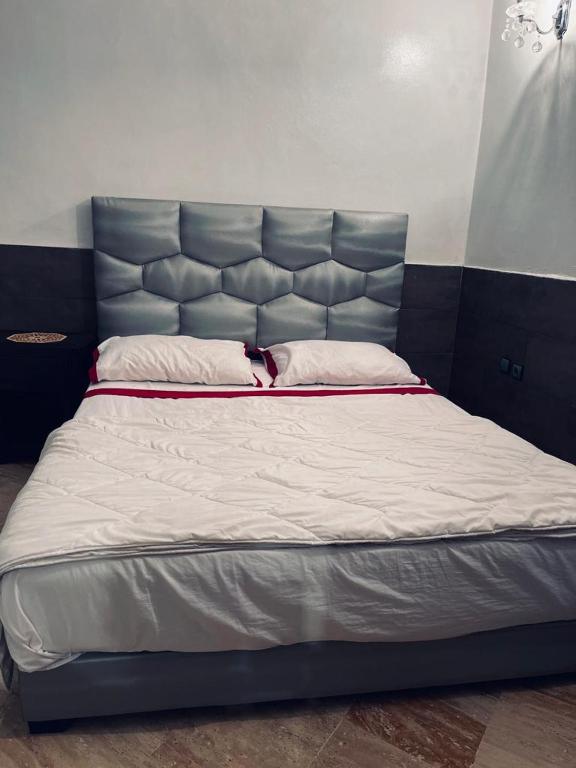a large bed with a blue headboard in a room at SINGAPOUR MAROC in Casablanca