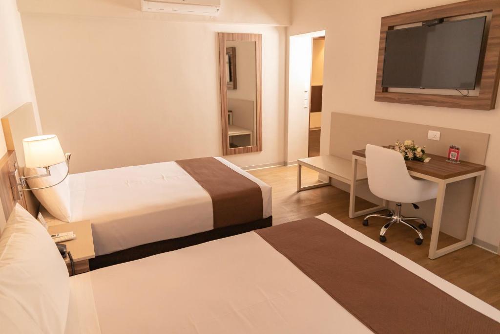 Postel nebo postele na pokoji v ubytování DM Hoteles Tacna