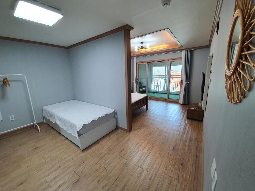 a bedroom with a bed and a room with a window at Namhae Manheim pension in Namhae