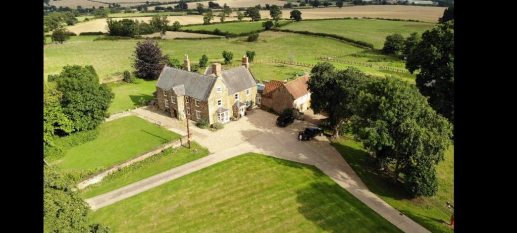 an aerial view of an old house in a field at The Groom's Cottage in Towcester