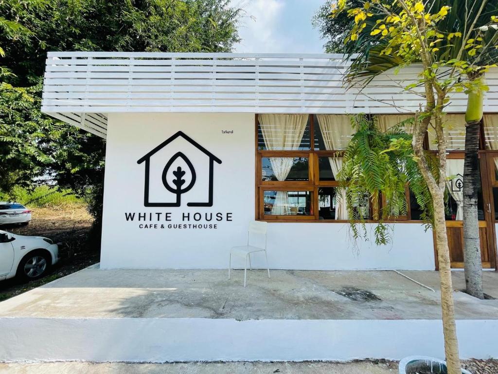 a white house sign in front of a building at Whitehouse cafe&Guesthouse in Ban Sa La