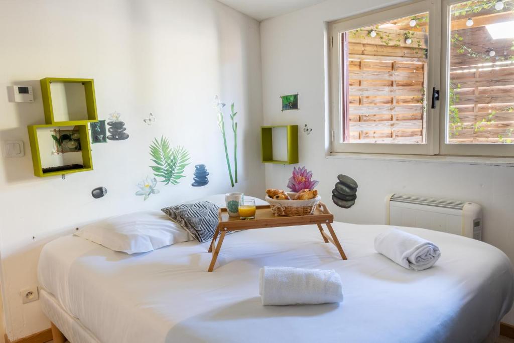 Cocooning Place في سانت إينيو: غرفة نوم مع سرير مع طاولة عليه