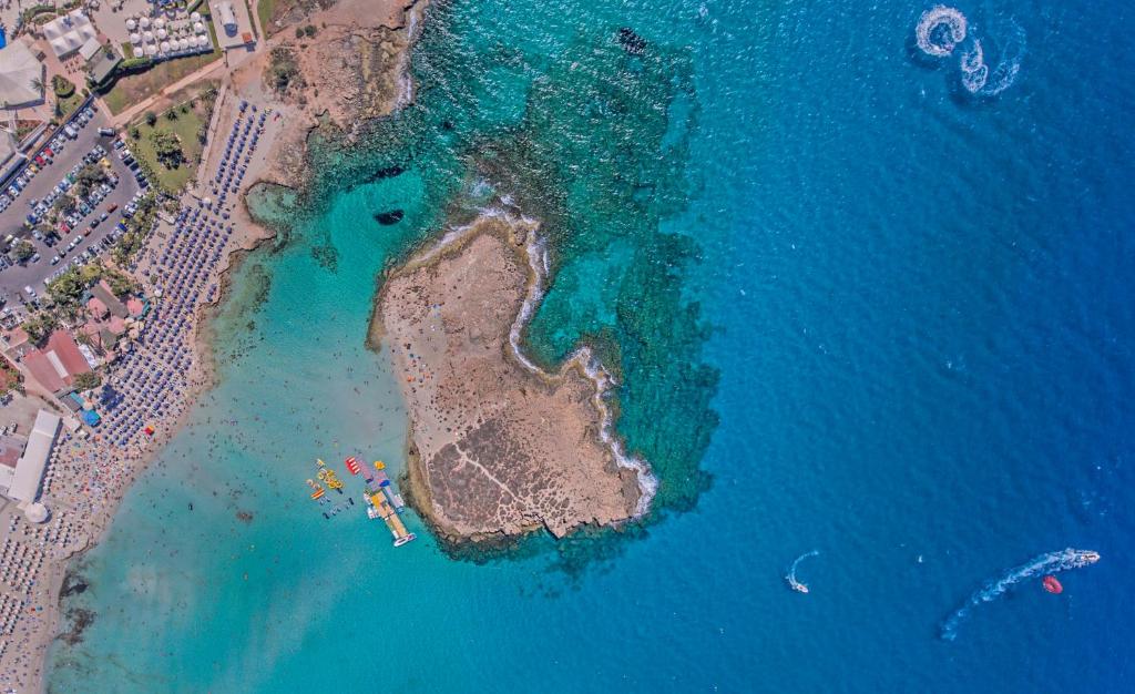 an aerial view of an island in the water at Chrysomare Beach Hotel & Resort in Ayia Napa