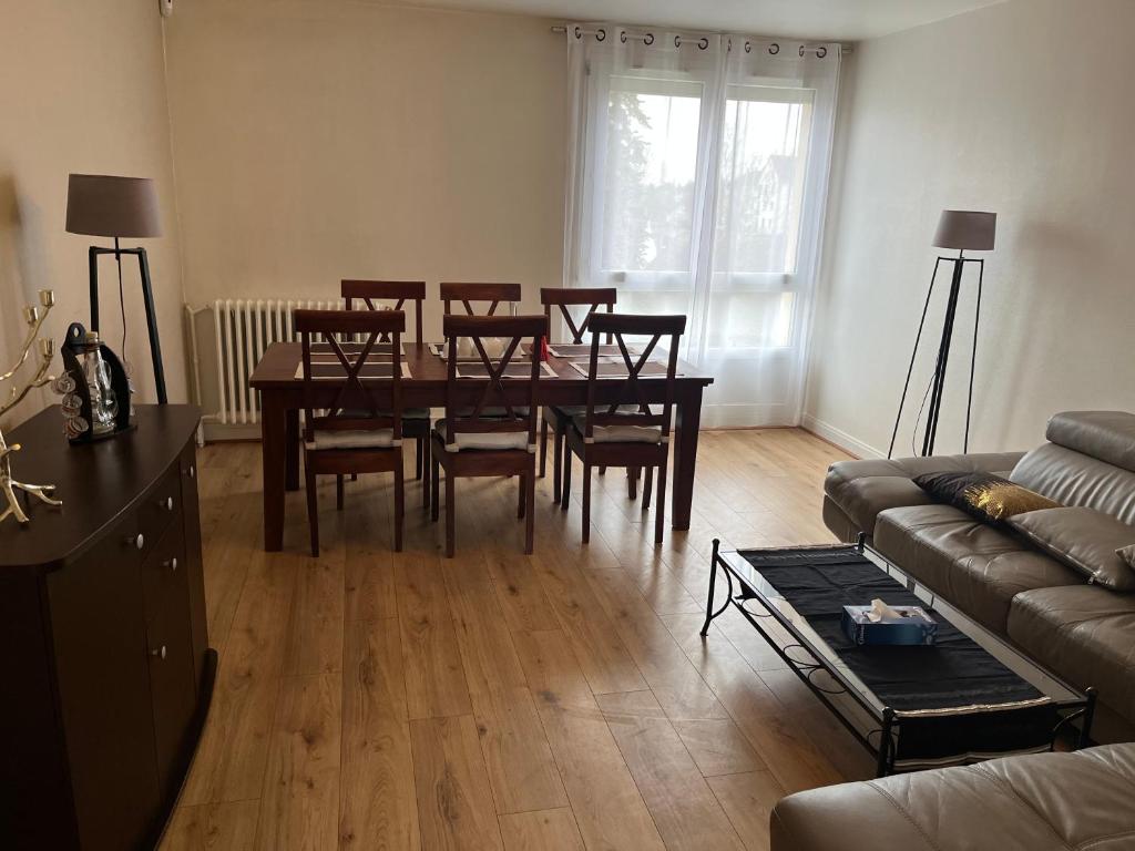 a living room with a dining room table and chairs at Chambre d hote au calme in Brétigny-sur-Orge