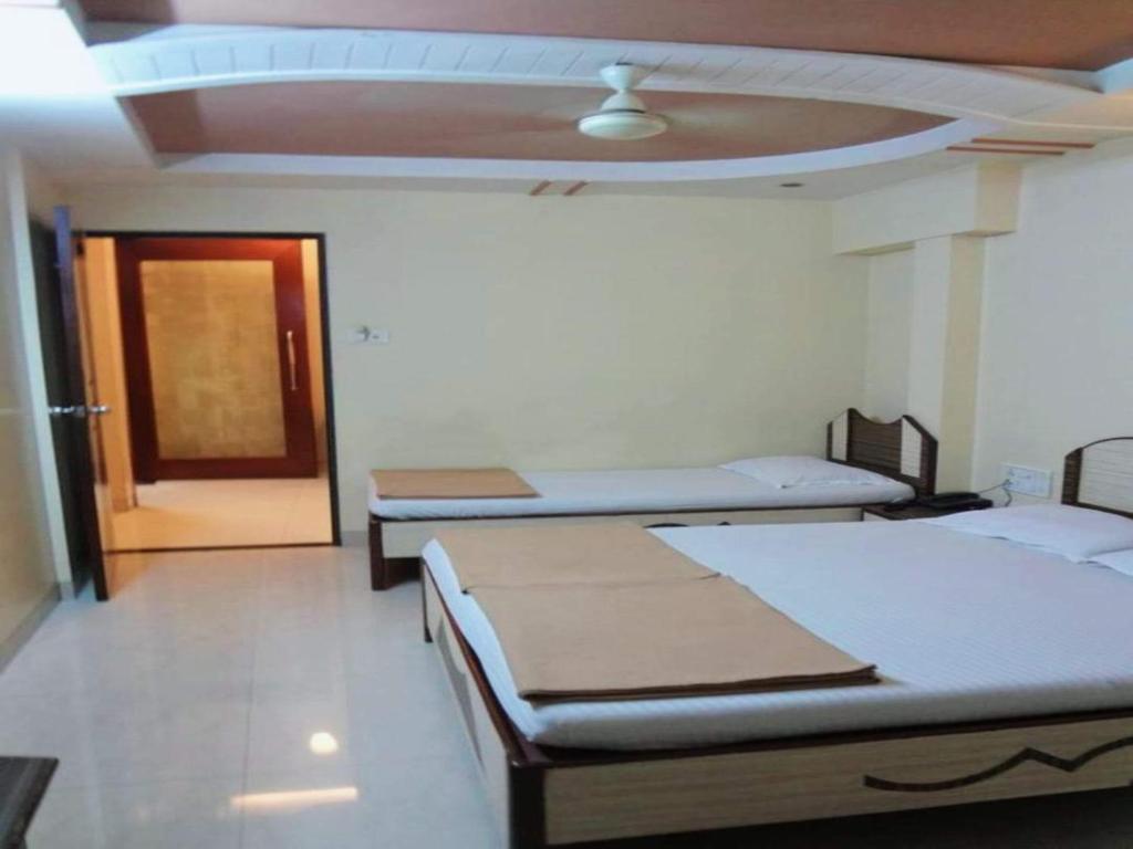 Postel nebo postele na pokoji v ubytování Hotel Broadway Colaba