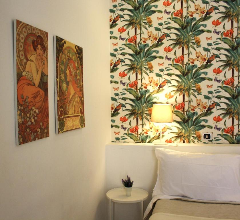 una camera da letto con un murale di piante sul muro di Locanda Dell'Arte a Napoli