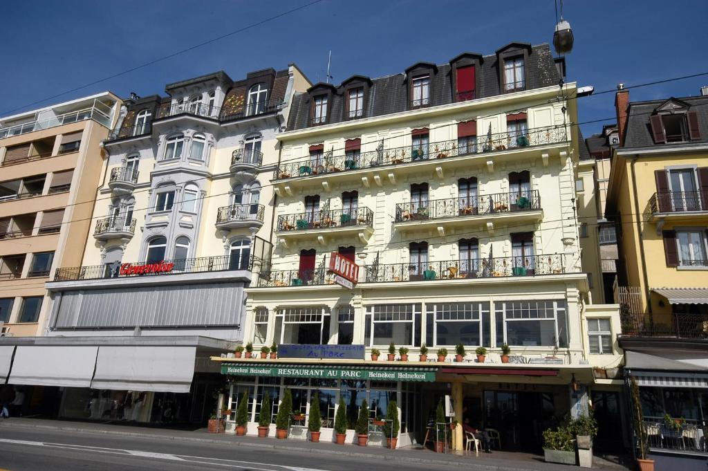 un grand bâtiment blanc avec balcon dans une rue dans l'établissement Hotel Parc & Lac, à Montreux