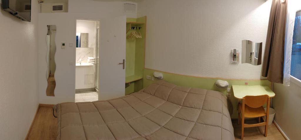 Habitación pequeña con cama y escritorio. en Fasthotel Well Inn Mâcon sud - un hôtel FH Confort en Charnay-lès-Mâcon