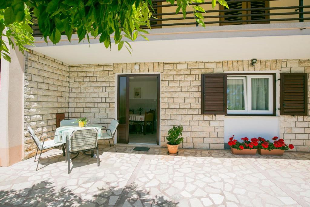 a patio of a house with a table and chairs at Apartman Vito in Labin