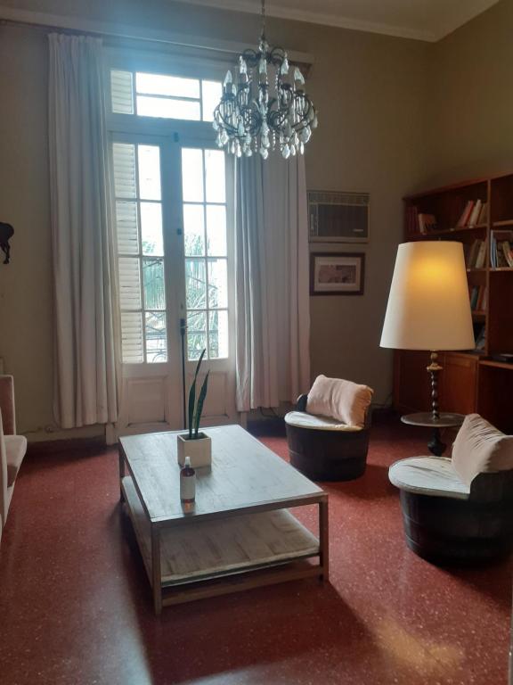 a living room with a table and a chandelier at Habitación en peatonal de Concordia 25000 PESOS LA NOCHE in Concordia