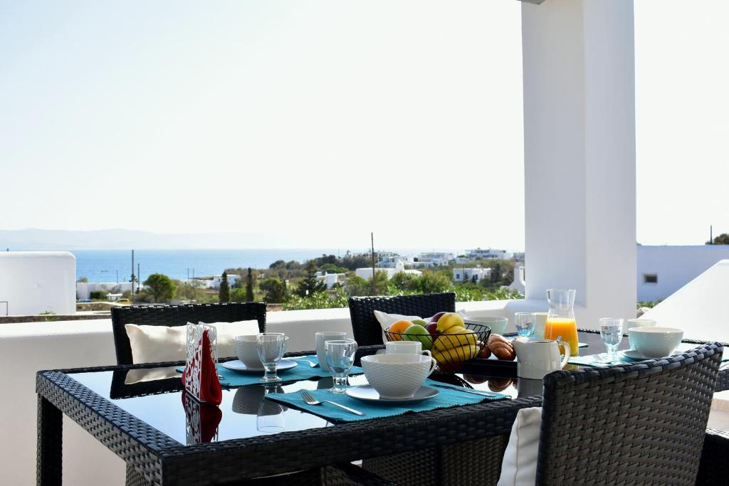 stół z jedzeniem i napojami na balkonie w obiekcie Parodise Apartment w mieście Paros