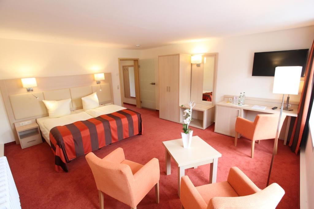 a hotel room with a bed and a table and chairs at Pension Ratskeller in Hagenow