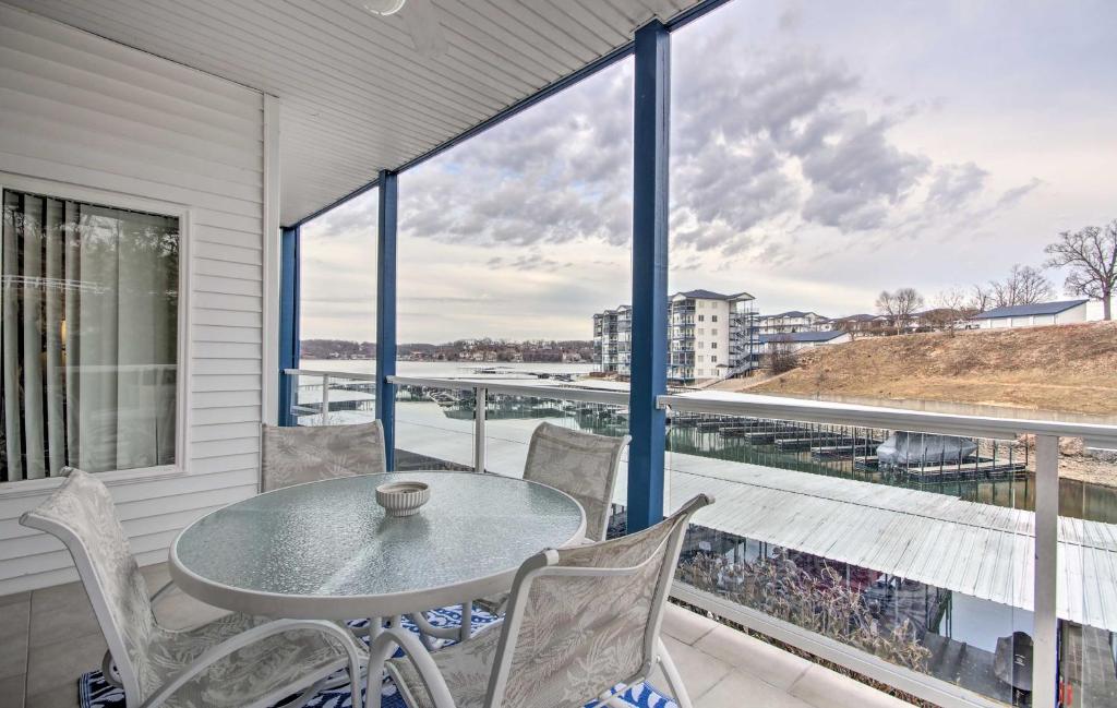 a table and chairs on a balcony with a view at Breezy Lake Ozark Escape Dock, Slip and Pool! in Lake Ozark