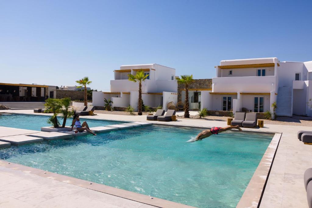 a man laying in a swimming pool in a villa at Adama Mykonos Boutique Hotel in Mikonos